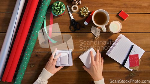 Image of hands packing earphones for christmas gift