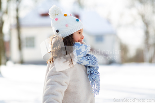 Image of happy little girl in winter clothes outdoors