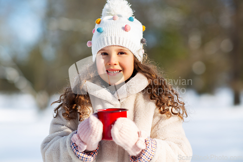 Image of little girl with cup of hot tea in winter park