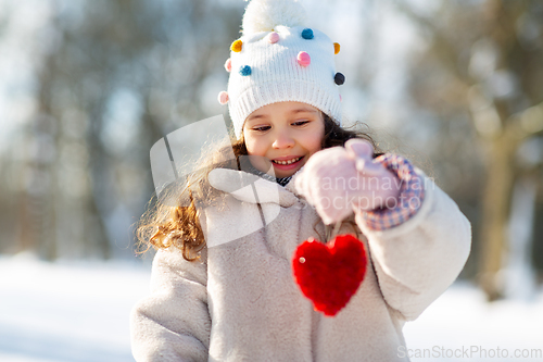 Image of happy little girl with heart outdoors in winter