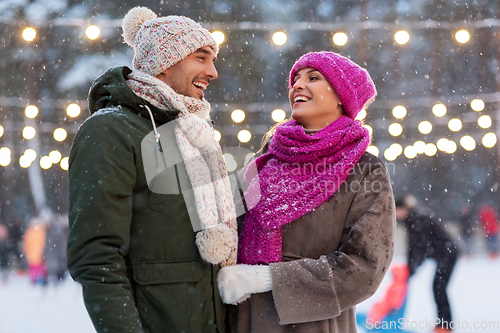 Image of happy couple at outdoor skating rink in winter