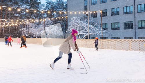 Image of happy woman at outdoor skating rink in winter