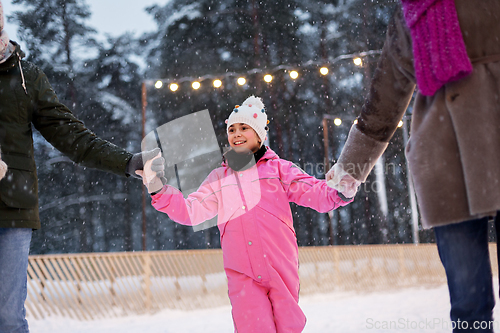 Image of happy family at outdoor skating rink in winter