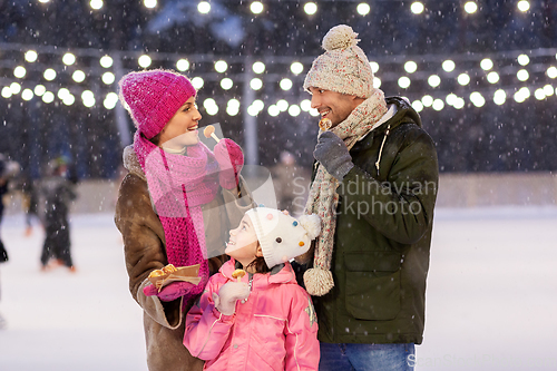 Image of happy family eating pancakes on skating rink