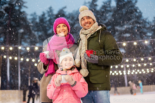 Image of happy family drinking hot tea on skating rink