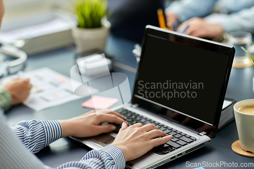 Image of businesswoman with laptop working at office