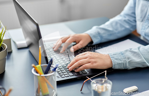 Image of businesswoman with laptop working at office
