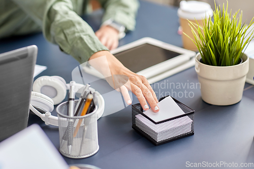 Image of businesswoman taking note paper at office