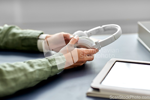 Image of close up of hands with headphones at office