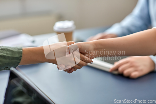 Image of close up of hands making handshake at office