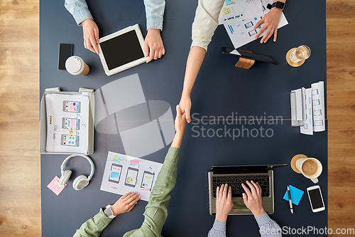 Image of business team makes handshake at office table