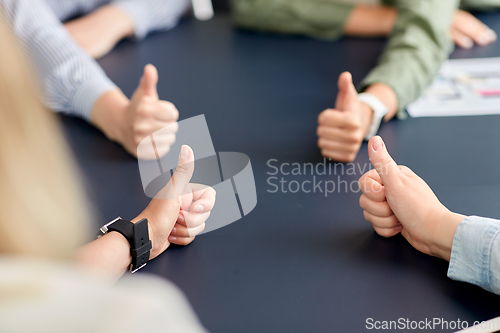 Image of close up of business team showing thumbs up