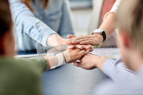 Image of close up of business team stacking hands