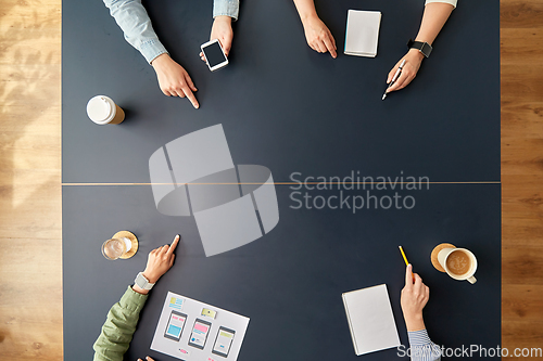 Image of business team pointing fingers to office table