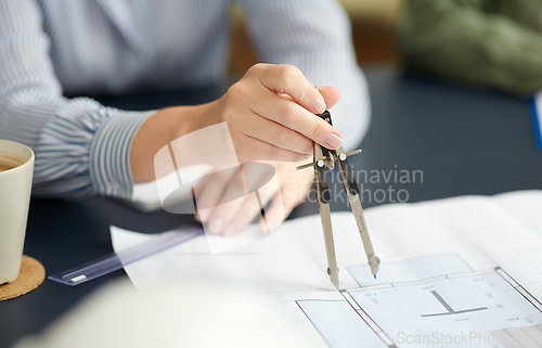 Image of architect with blueprint and drafting compass