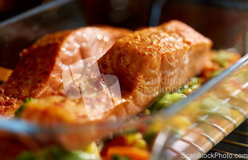 Image of food cooking in baking dish in oven at home