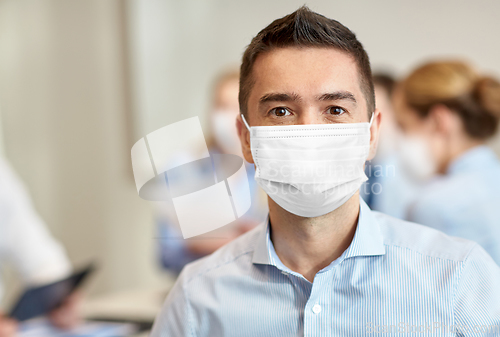 Image of businessman wearing face protective mask at office