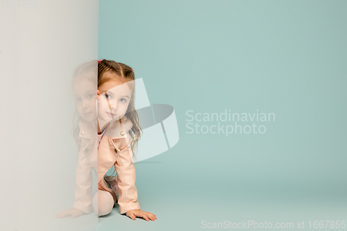 Image of Happy kid, girl isolated on blue studio background. Looks happy, cheerful, sincere. Copyspace. Childhood, education, emotions concept