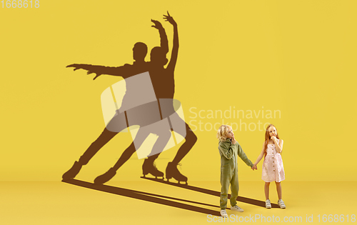 Image of Childhood and dream about big and famous future. Conceptual image with boy and girl and shadows of fit athletes, figure skating sportsmen.