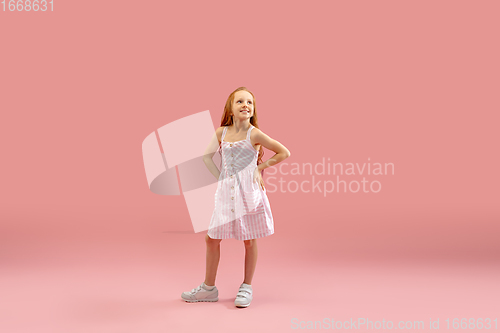 Image of Childhood and dream about big and famous future. Pretty longhair girl isolated on coral pink background