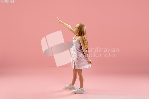 Image of Childhood and dream about big and famous future. Pretty longhair girl isolated on coral pink background