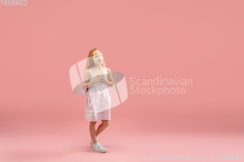 Image of Childhood and dream about big and famous future. Pretty longhair girl isolated on coral pink background