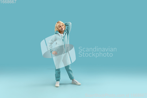 Image of Childhood and dream about big and famous future. Pretty curly boy isolated on blue background