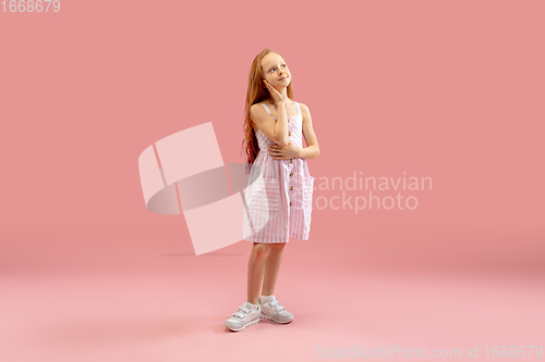 Image of Childhood and dream about big and famous future. Pretty longhair girl isolated on coral pink background