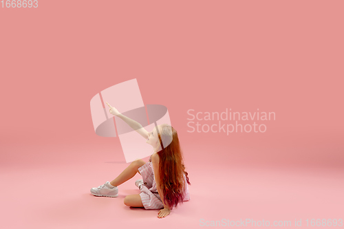 Image of Childhood and dream about big and famous future. Pretty longhair girl isolated on coral pink background