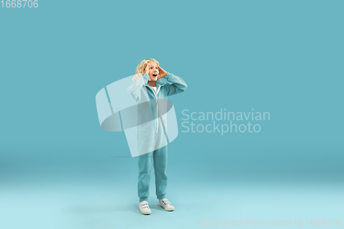 Image of Childhood and dream about big and famous future. Pretty curly boy isolated on blue background