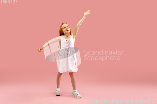 Image of Childhood and dream about big and famous future. Pretty longhair girl isolated on coral pink background