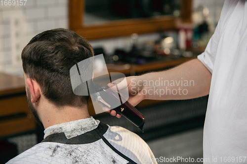 Image of Close up of client of master barber, stylist during getting care