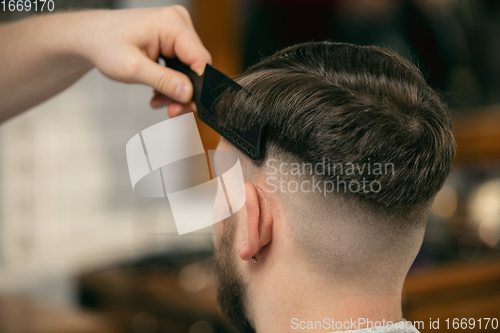 Image of Close up of client of master barber, stylist during getting care