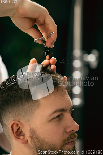 Image of Close up of client of master barber, stylist during getting care of hairstyle. Professional occupation, male beauty concept