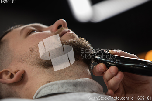 Image of Close up of client of master barber, stylist during getting care