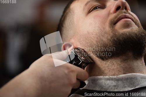 Image of Close up of client of master barber, stylist during getting care