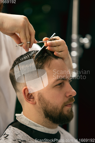 Image of Close up of client of master barber, stylist during getting care