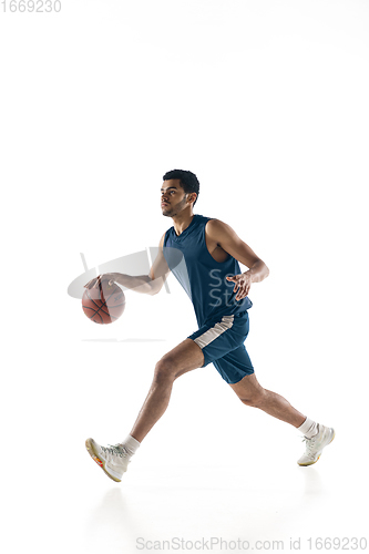 Image of Young arabian basketball player of team in action, motion isolated on white background. Concept of sport, movement, energy and dynamic.