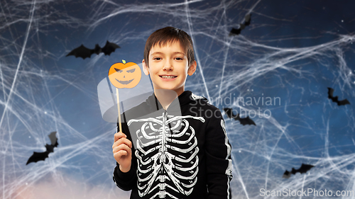 Image of boy in halloween costume of skeleton with pumpkin