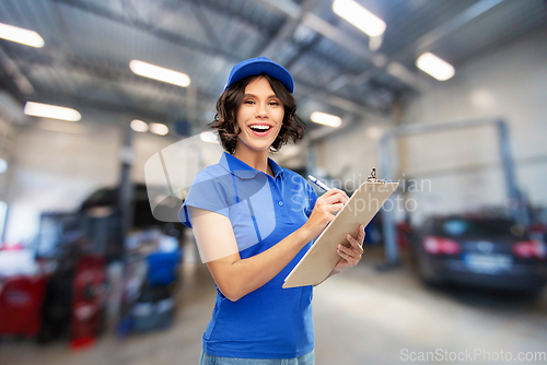 Image of female worker with clipboard at car service