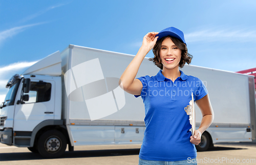 Image of happy delivery girl with clipboard and pen writing