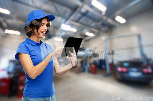 Image of happy female worker with tablet pc at car service