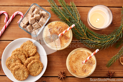 Image of glasses of eggnog, oatmeal cookies and fir branch