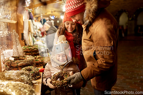 Image of happy family buing wreath at christmas market