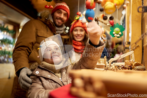 Image of happy family buying souvenirs at christmas market