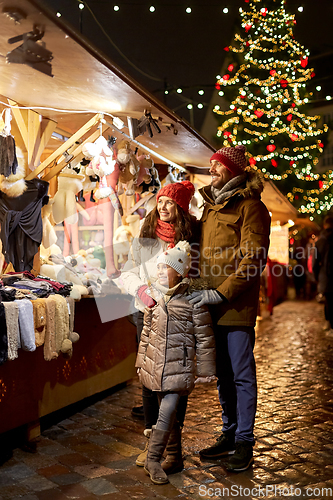 Image of happy family at christmas market in city