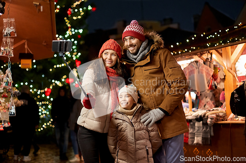 Image of happy family taking selfie at christmas market