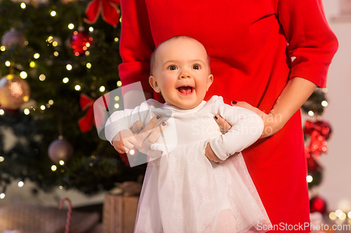 Image of mother with happy baby daughter at christmas tree