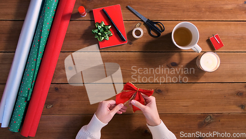 Image of hands with bow for christmas gifts wrapping