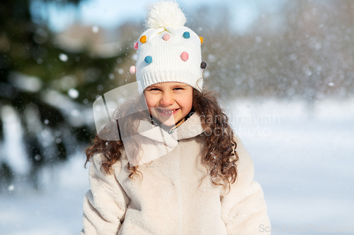 Image of happy little girl in winter clothes outdoors